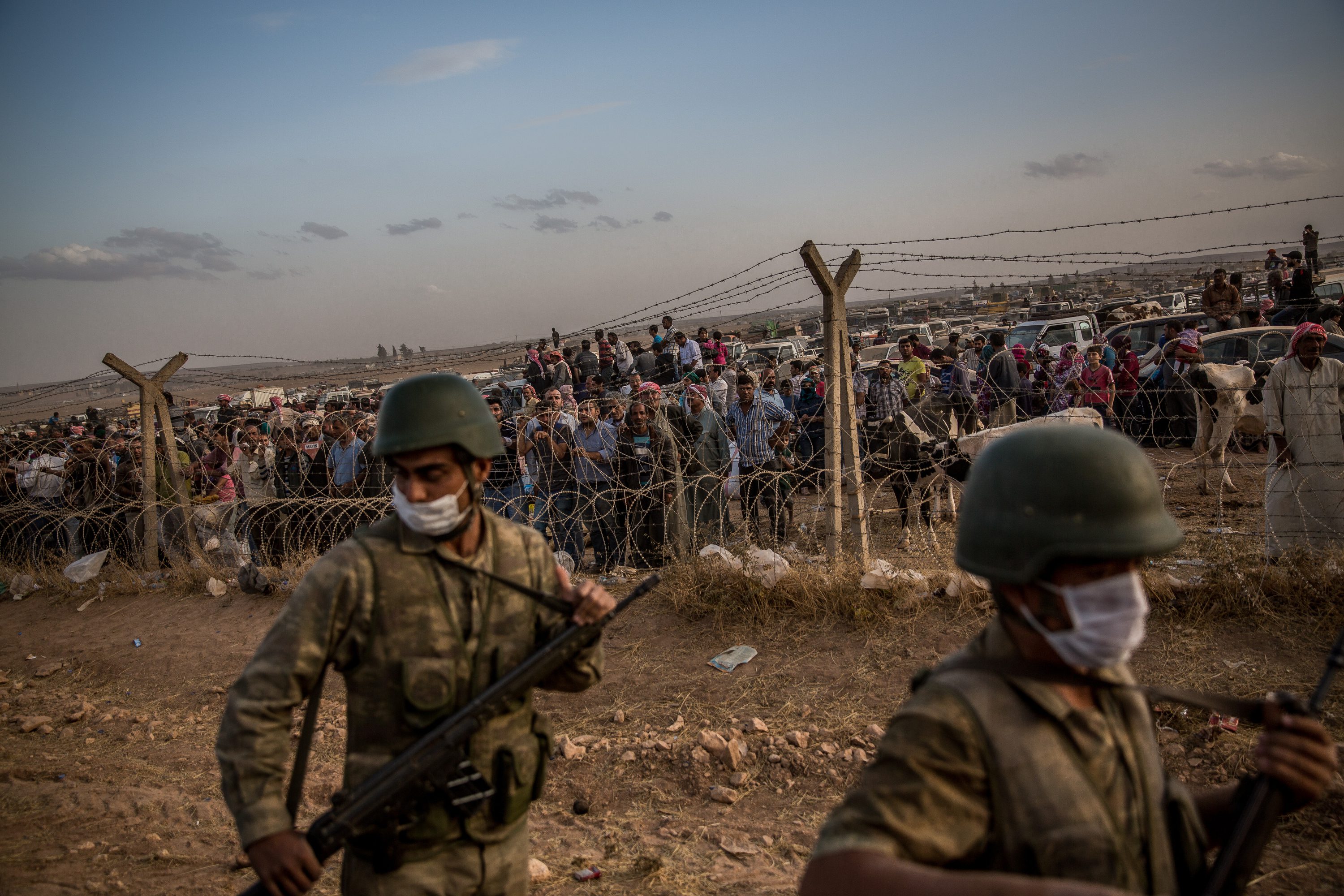 Turkish Soldiers Patrol A Border Fence As A Crowd Of Syrian Kurdish Refugees Watch And Wait At 7523