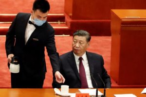 El jefe de estado chino, Xi Jinping, es atendido por un asistente durante una cumbre en el Gran Hall del Pueblo de China, en Beijing 