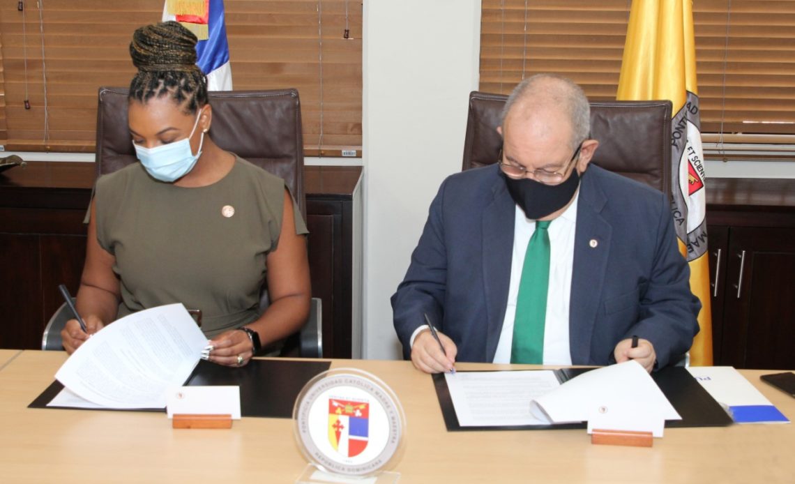 Firman el acuerdo, Doralyn De Dios, presidenta de la DBA y David Álvarez Martín, rector de la PUCMM