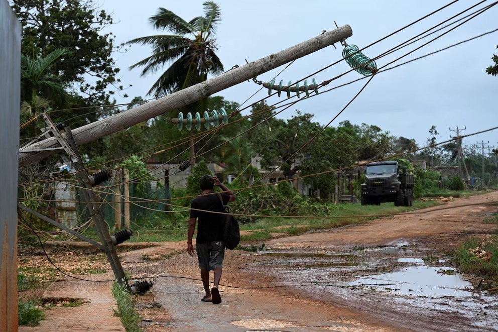 Un hombre camina junto a cables eléctricos caídos tras el paso del huracán Rafael en Guira de Melena, provincia de Artemisa, Cuba, el 7 de noviembre de 2024